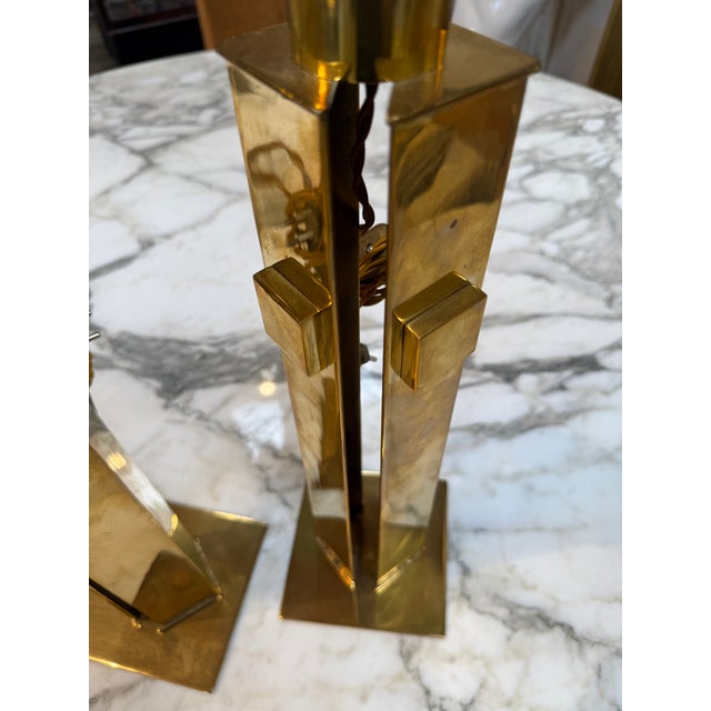 Striking pair of sculptural brass table lamps featuring bold geometric forms and an architectural modernist silhouette....