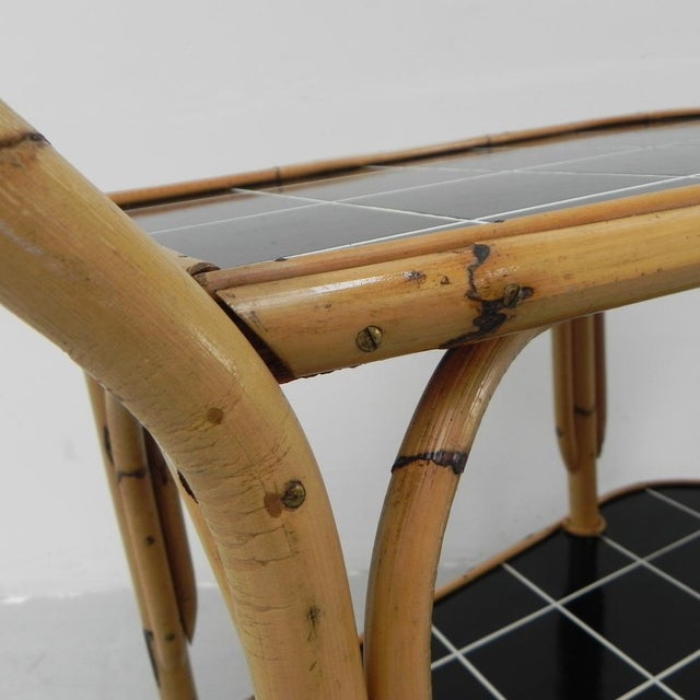 Height: 72 cm. Width: 75 cm. Depth: 43 cm. The trolley has 2 wooden shelves with a kind of tile motif. The top tile motif...