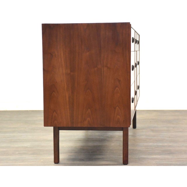 A mid century modern walnut nine drawer dresser designed by Jack Cartwright for Founders with inset pulls. Professionally...