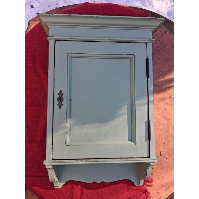 An antique wall cabinet in a delicate sage green, ready for another 100 years of use. Approximate dimensions: Height 65...