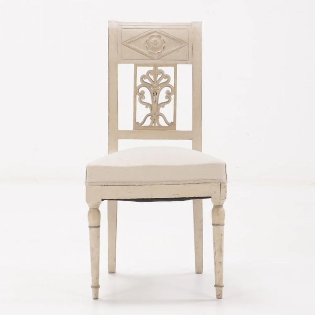 Comprised of six side chairs all painted and of pegged construction. Having rosette and diamond carved crests above...