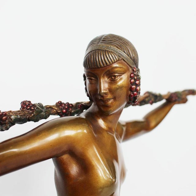 Bacchante, a cold painted, gilt bronze sculpture. Depicting a bare breasted maiden in active dance pose holding aloft a...