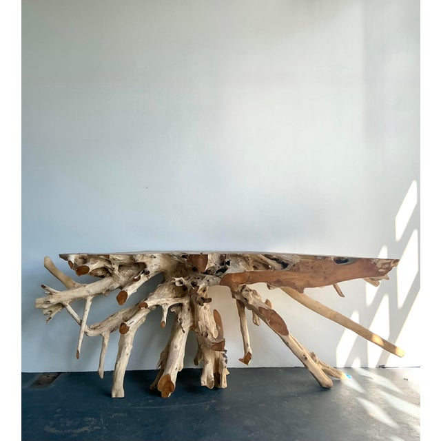 This monumental console table is a breathtaking marriage of raw nature and refined artisanal craft. Hewn from a massive,...