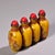 This is a set of four matching yellow glass snuff bottles, each featuring a hand-painted portrait of one of the "Four...