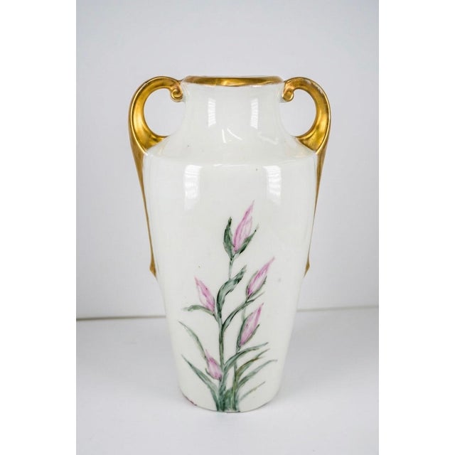 Exquisite early 20th-century porcelain vase, hand-painted with vibrant purple and pink irises. This elegant double-handled...