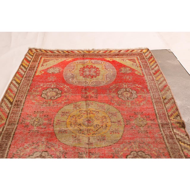 Originating from East Turkestan in 1920s, this antique traditional Khotan rug from Rug & Kilim has a distinct medallion-...