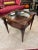 An exquisite Occasional Table by Heirloom Weiman. Crafted to perfection, this square table boasts a resplendent round...