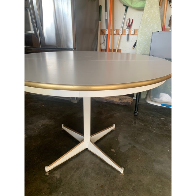 42 inch round white, wood, Formica, and steel based Walter Wabash dining table. 28 inch high with adjustable feet....