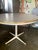 42 inch round white, wood, Formica, and steel based Walter Wabash dining table. 28 inch high with adjustable feet....