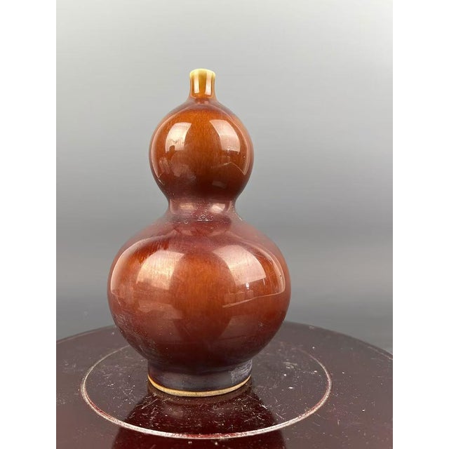 Crafted during the Qing Dynasty, this Chinese Vintage Porcelain Vase features a stunning flambé glaze and is marked with...