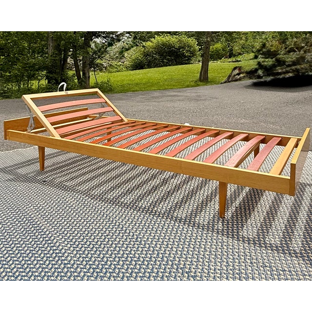 Vintage adjustable daybed by Swiss maker Hasena, featuring a warm wood frame, tapered legs, and an articulated backrest...