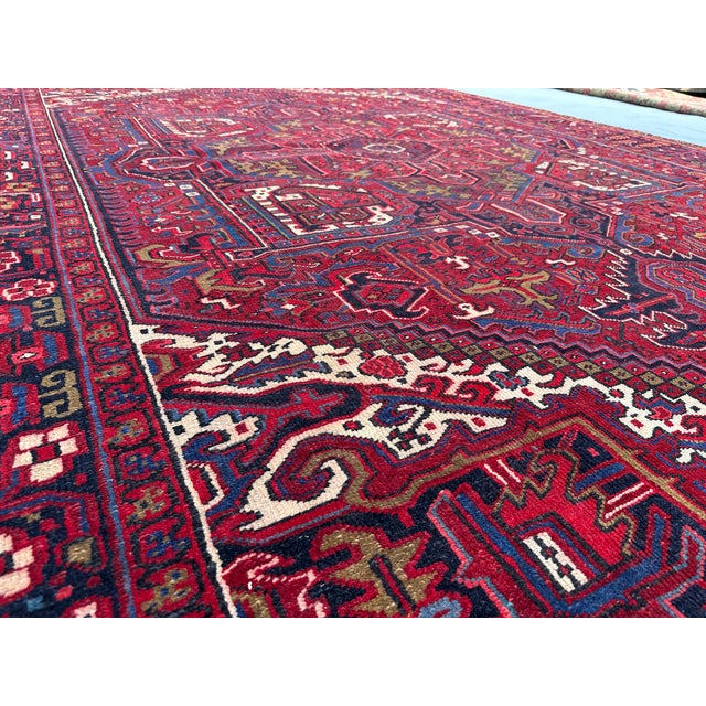 This magnificent vintage rug, hand-knotted in the 1960s, showcases the bold and intricate Heriz design, renowned for its...