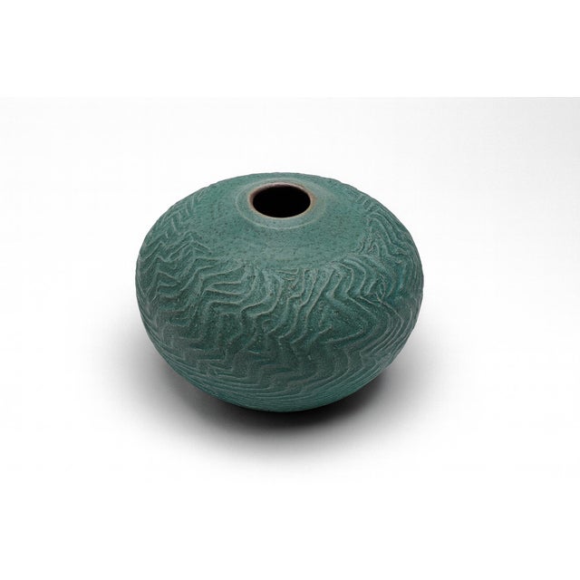 A signed round vase from Kenai, AK with a textured surface that calls to mind topo curves, shoreline sand, and natural...