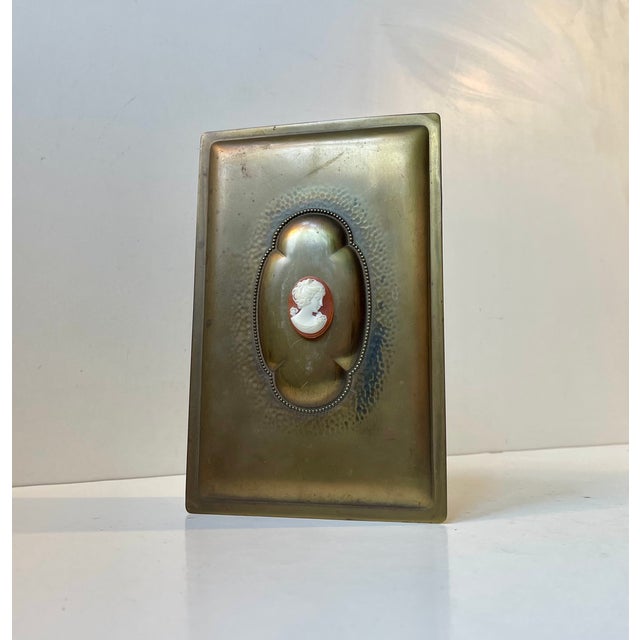 Unusual Danish cigar box in partially hammered, patinated and embossed brass. It is linned with teak and has a bakelite...