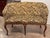 A pair of walnut settees in the Louis XV style, each with a shaped back that dips at the center and curves outward at the...