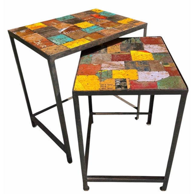 Distinctive vintage industrial nesting tables featuring tops crafted from reclaimed painted metal signage fragments...