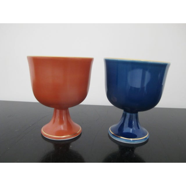Set of 2 Arita-Yaki or Imari-Yaki porcelain cups in original boxes. One reddish orange tone and one cobalt blue, each with...