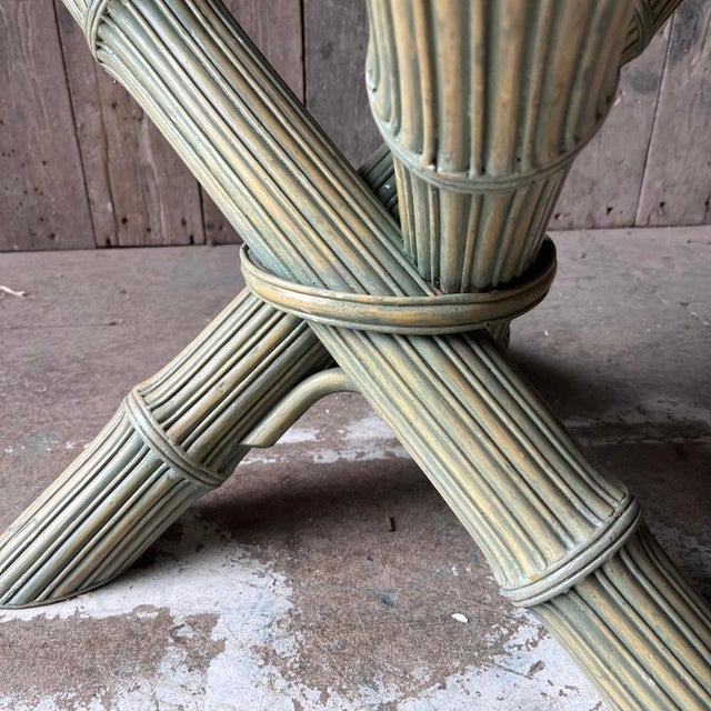80s Green stained faux bamboo with a crossed effect base and round glass top The table has a green wash effect Dimensions...