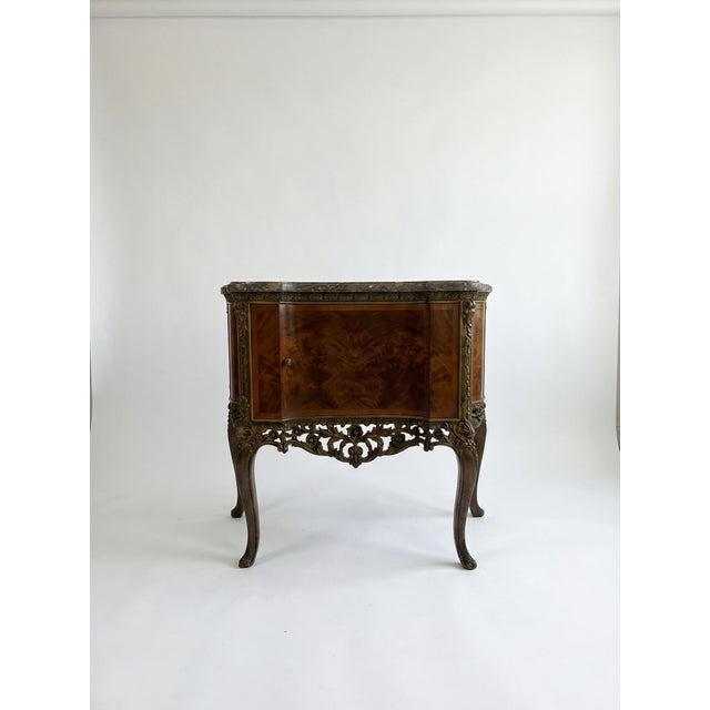 A stunning mid-century French XV-style demi-lune chest console. This richly detailed piece features book-matched burled...