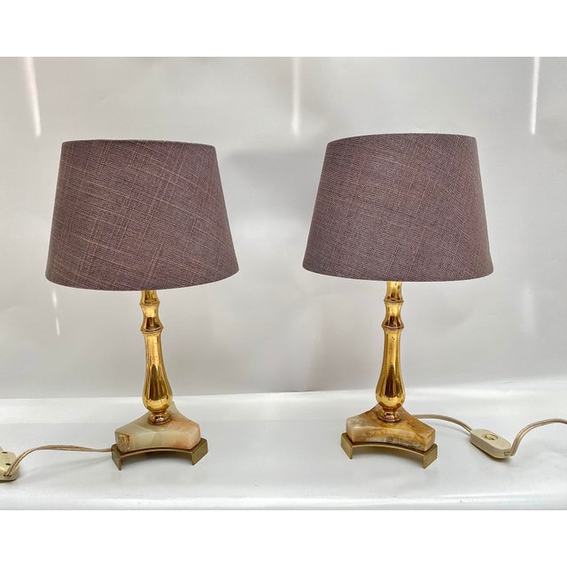 Charming pair of vintage table lamps hails from Belgium, circa 1970s. They feature elegant bases crafted from onyx, brass,...