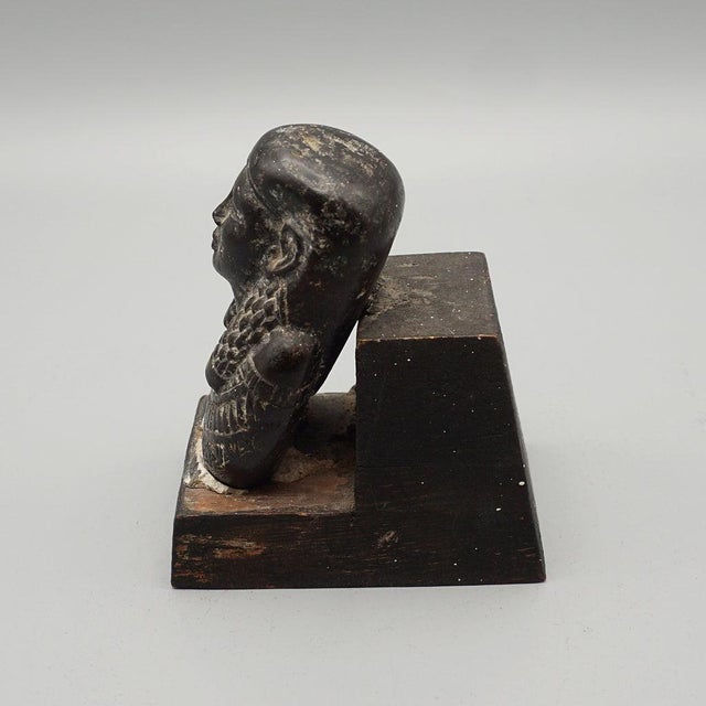 An Ancient Egyptian relief carved balsalt Ushabti figure, wearing a detailed head dress and collar. Usually buried with...