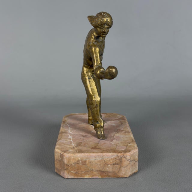 An expressive gilded bronze tabletop figurative sculpture depicting a bocce player, attributed to 20th-century...