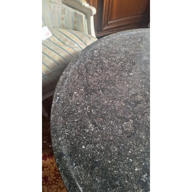Empire-style pedestal table with a central marble top and mahogany legs. A molding is visible around the marble. Period:...