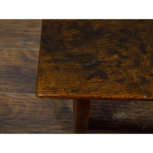 An English oak side table from circa 1800 with planked top, slender straight legs and side stretchers. This English oak...
