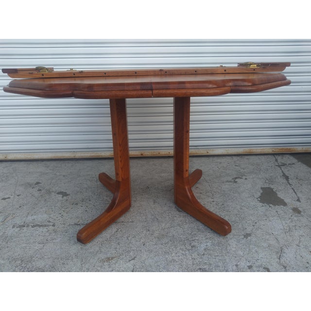 This is an unusually shaped dining table. The edge is scalloped and it has a split pedestal base. The top is made in the...