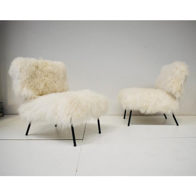 Pair of vintage 1970s armchairs, Italian manufacture. The armchairs feature an iron leg with seat and back covered in...