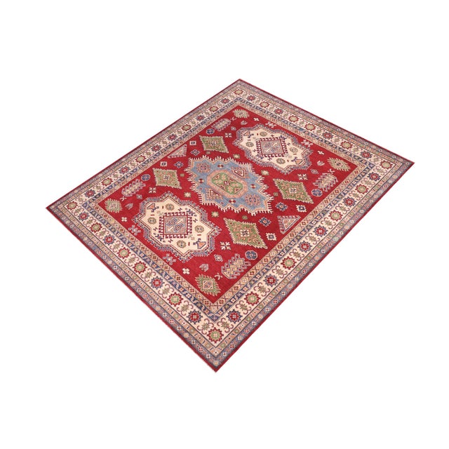 Enhance your home with this exquisite hand-knotted Kazak rug, crafted from fine hand-spun wool and dyed with all-natural...