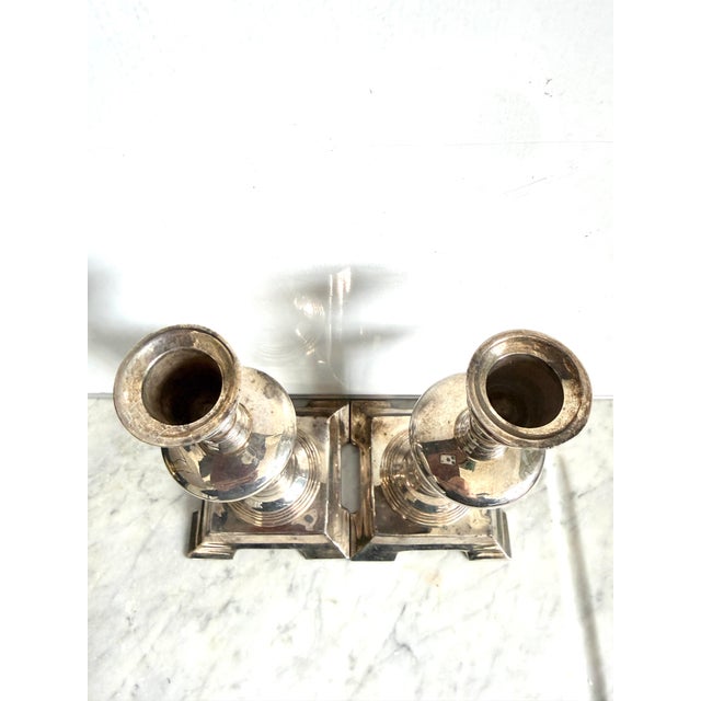 A pair of antique silver-plated candlesticks. Manufacturer unknown but they do have the numbers 4564-4 etched on the...