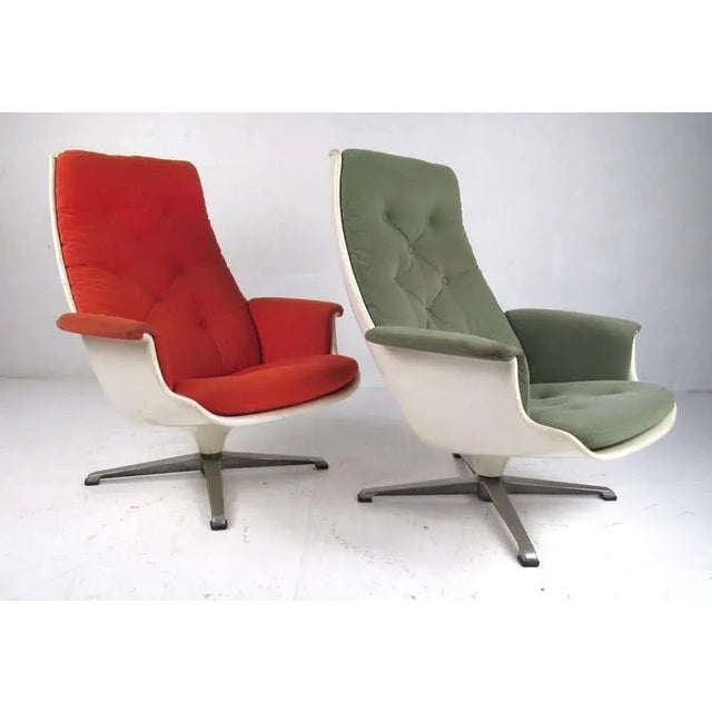 Matching pair of vintage fiberglass shell lounge chairs on swivel bases. Reminiscent of the classic Eames lounge, these...