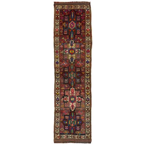 This exquisite runner rug is a rare example of tribal craftsmanship, hand-knotted by the women of the Herki tribe during...