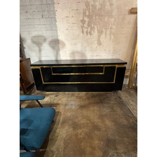 The Jean Claude Mahey Design Black Lacquer and Brass Sideboard is a stylish and sleek piece of furniture. With a handsome...