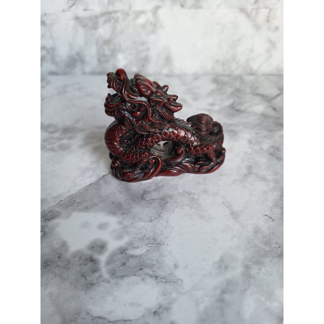 Japanese netsuke carved out of wood with a reddish stained finish. This dragon appears to be circa mid-20th century.