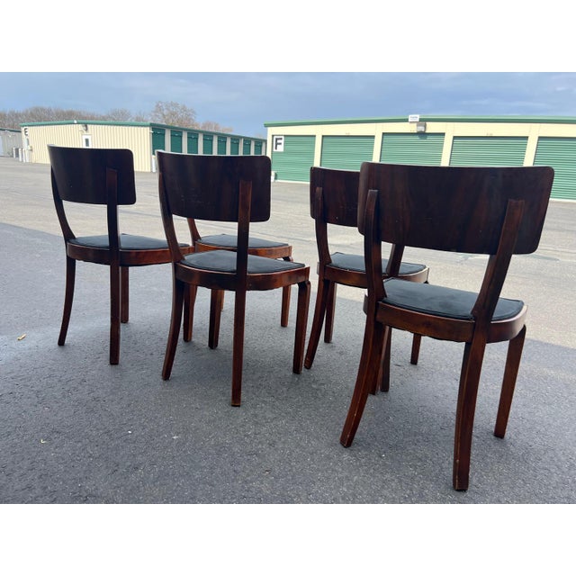 Elegant dining chairs crafted circa 1980s in the Biedermeier Revival style, featuring beautifully figured wood backs with...