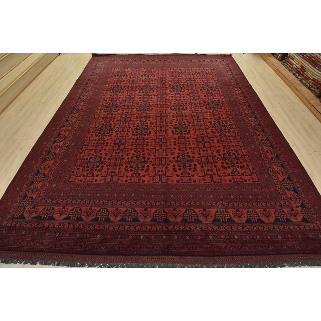A traditional Turkmen rug hand-knotted with fine wool and natural dyes. This rug features rows of geometric medallions...