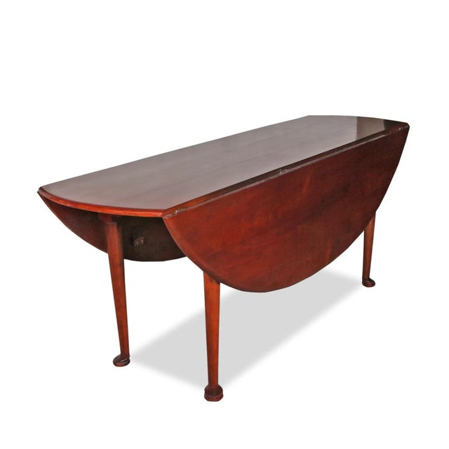 Magnificent antique George III Irish mahogany table, featuring a smooth oval top with a pair of drop leaves, supported by...