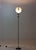 This is a Polifemo floor lamp designed by Carlo Forcolini for Artemide in the 1980s. It has a black metal frame with a...