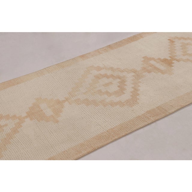 Hand-knotted in wool and originating from Turkey circa 1950-1960, this 3x8 vintage Tulu runner rug is a rich find among...