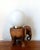 Stunning solid wood sculpture of an elephant, mounted as a table lamp/nightlight with a white opaline glass shade. Gold-...