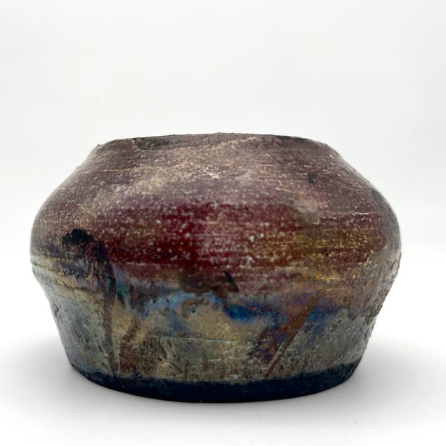 Studio handmade pottery pot with stunning splashes of green, red, blue, yellow, brown colors. Soda-firing process in the...