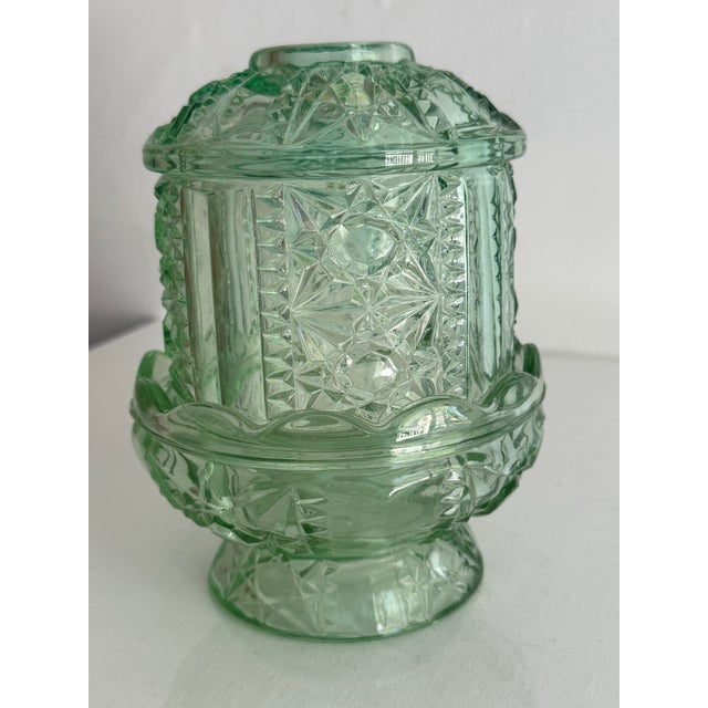 Vintage light green pressed glass fairy lamp, with Stars and Bars pattern. Has a scalloped footed base and patterned dome....