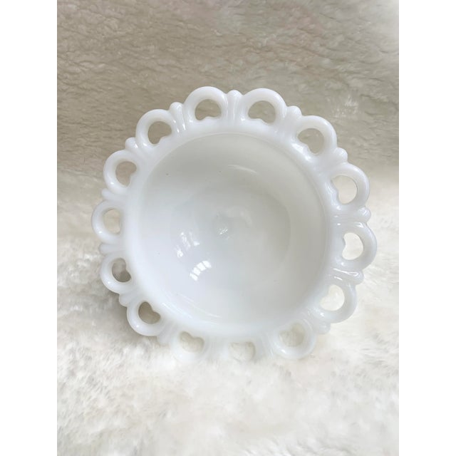 Vintage milk glass pedestal dish with lace edges in pristine condition.