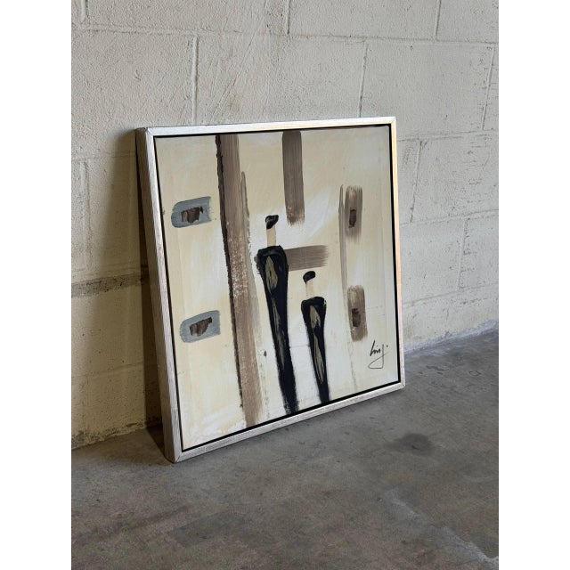 This striking canvas painting features an abstract composition depicting two figures in neutral and dark tones. Framed...