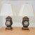 Sophisticated pair of vintage Chelsea House table lamps. Features hand-painted black tole neoclassical trophy urn...