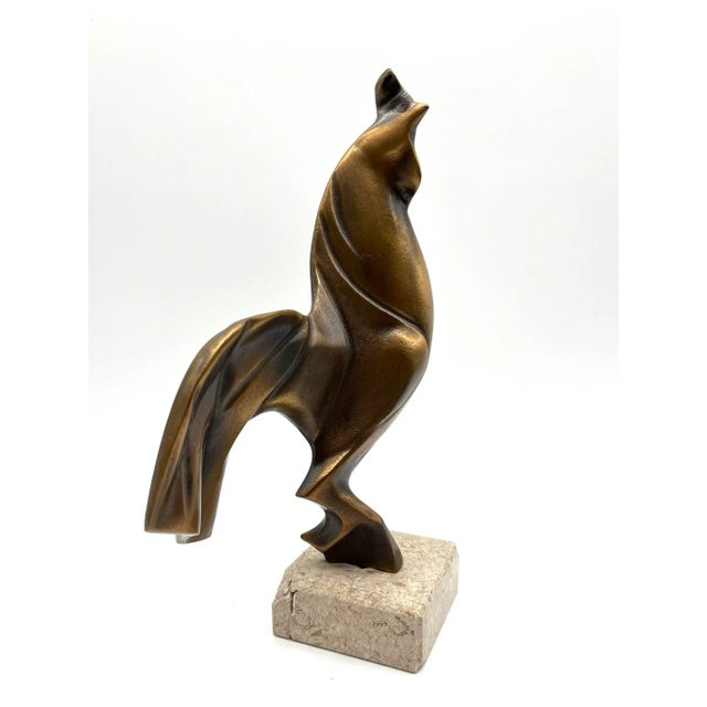 This distinctive sculpture depicts a rooster in an abstract form and is crafted from solid bronze. The dynamic, stylized...