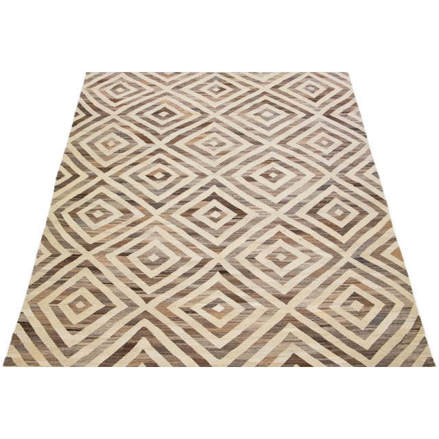 Beautiful Modern Kilim hand-knotted wool rug with a geometric abstract design on a beige field and brown accents...