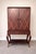Art deco style bar cabinet in a dark wood finish with a distinctive geometric inlay pattern. The interior is lighted and...